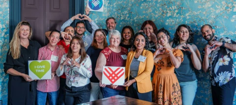 A photo of people looking smiling and celebrating Giving Tuesday