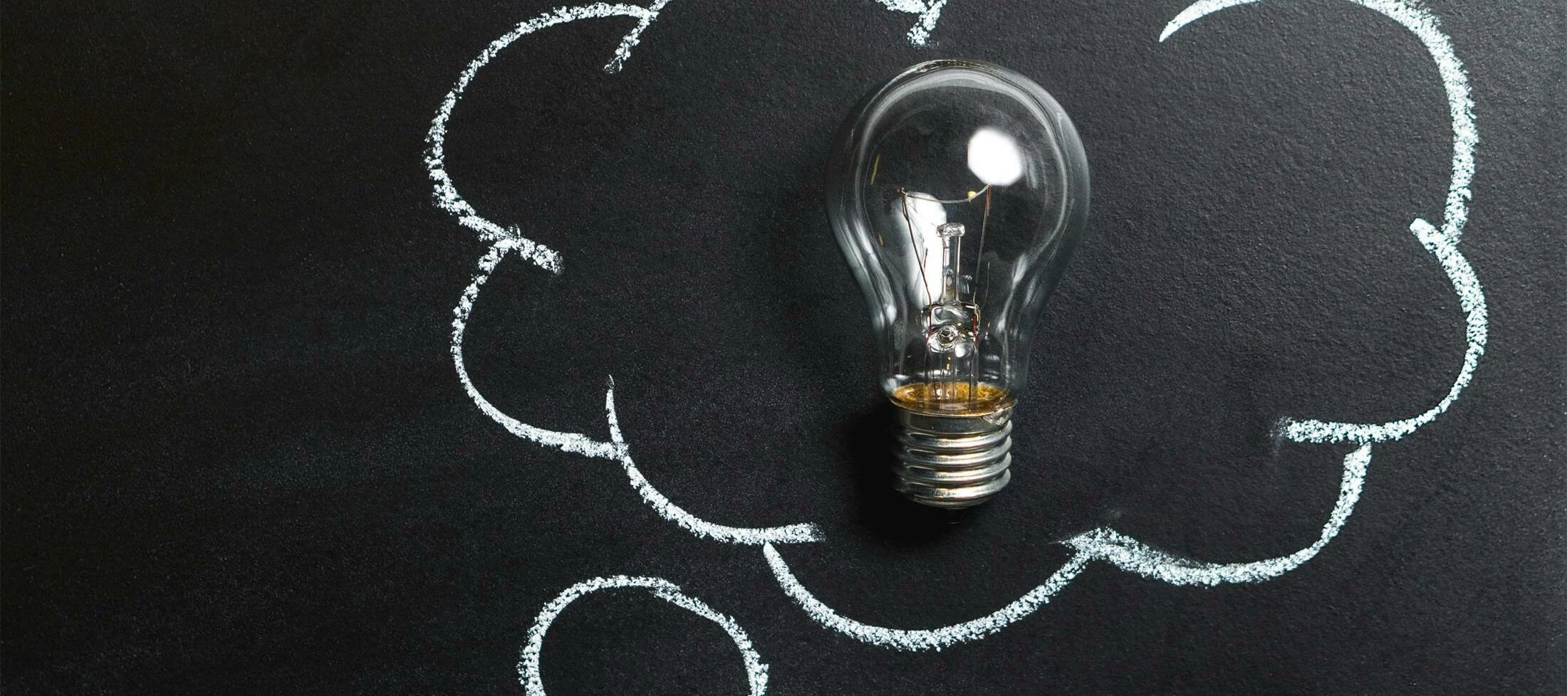 lightbulb on a chalkboard that is surrounded by a think bubble