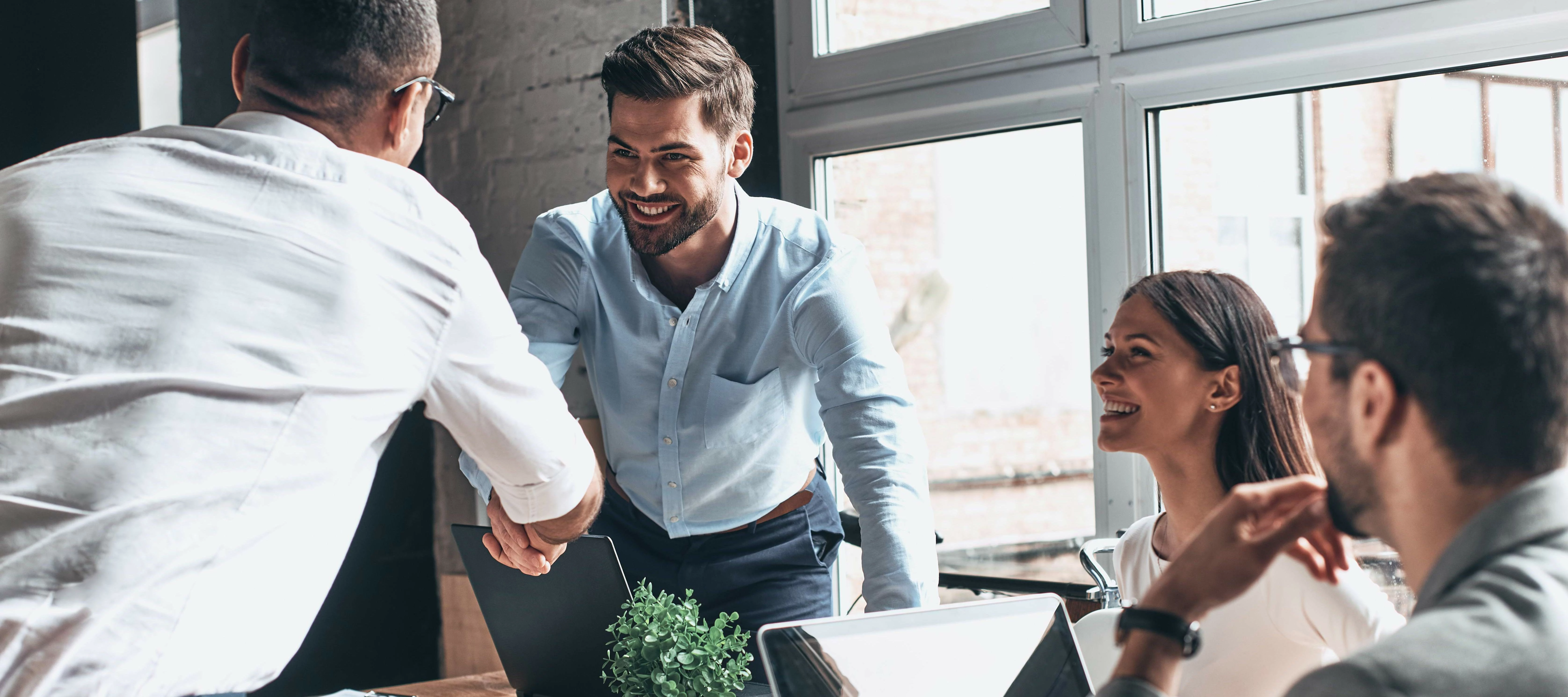 business meeting with people shaking hands and smiling