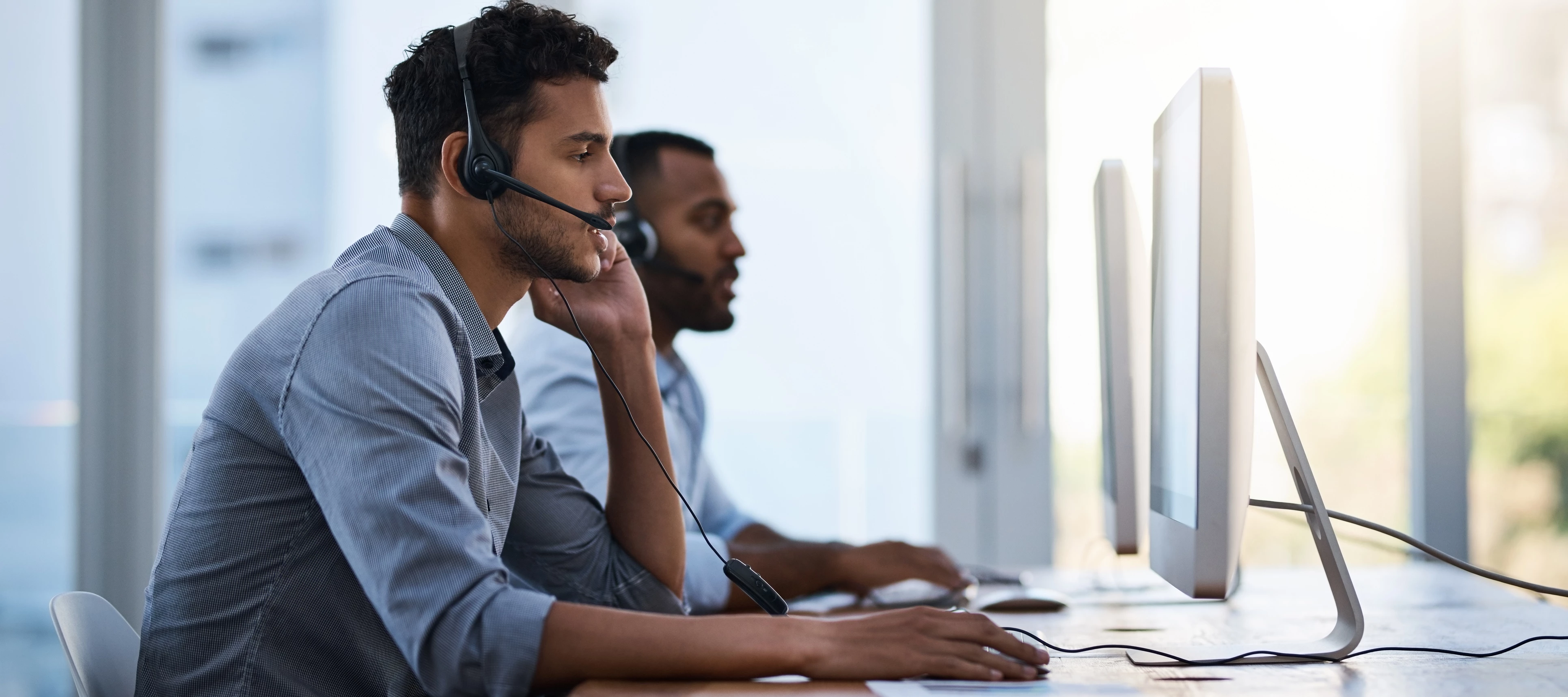 two technical support employees on the phone with headsets