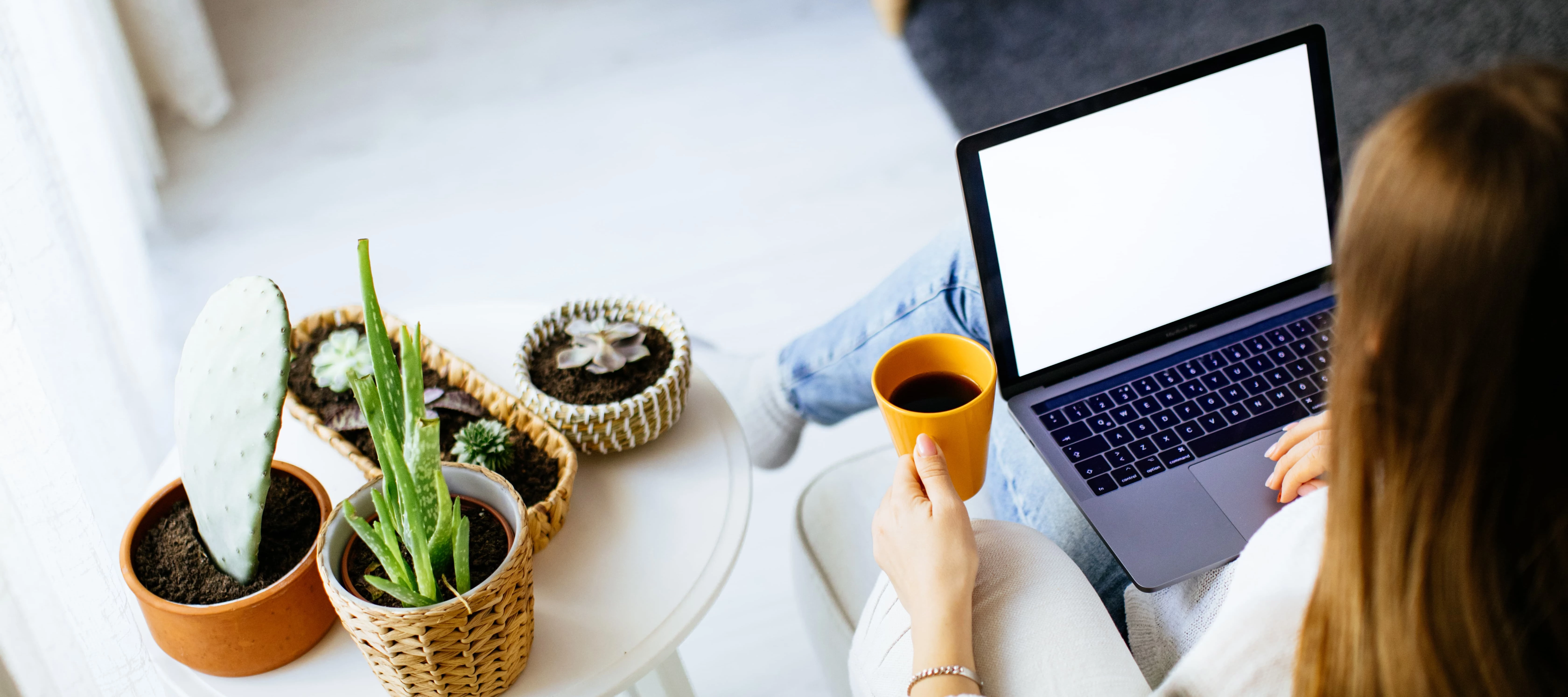 Woman sitting on with her laptop and a coffee