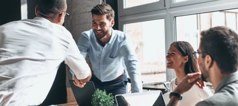 business meeting with people shaking hands and smiling