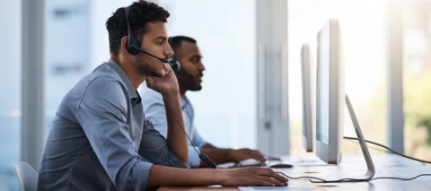 two technical support employees on the phone with headsets