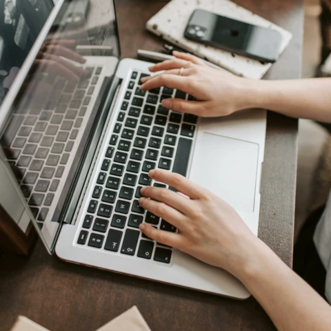 person typing on their laptop at a desk