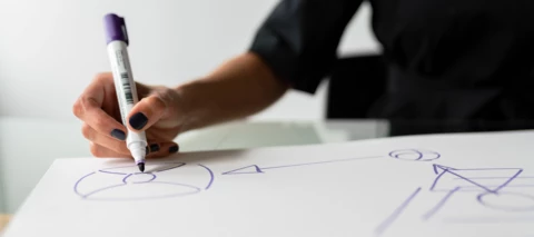 person writing a change management diagram and flow